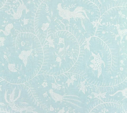 A fabric with a Chinoiserie print featuring Javanese mythological animals, swirling vines, and flowers on a light blue background.