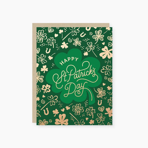 A greeting card with a green background and gold foil designs, including shamrocks and the text 'Happy St. Patrick's Day'.