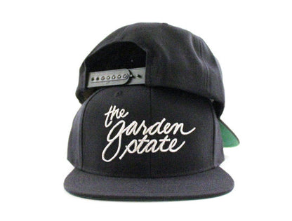 The Garden State Script Snapback Hats (Navy Green Under Brim)