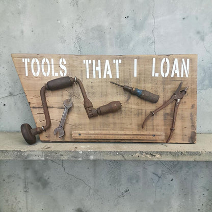Handmade rustic Tools That I Loan garage sign with five useless tools